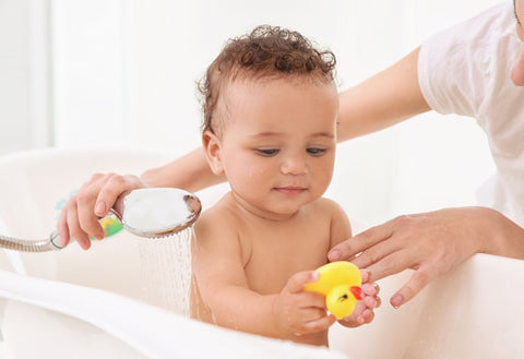Baby being bathed by parent