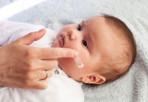 small baby, mother applying cream to face