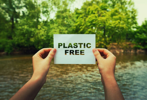 Hands holding sign that says Plastic-Free