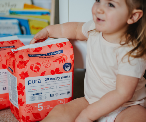 Little girl with pack of Pura nappy pants