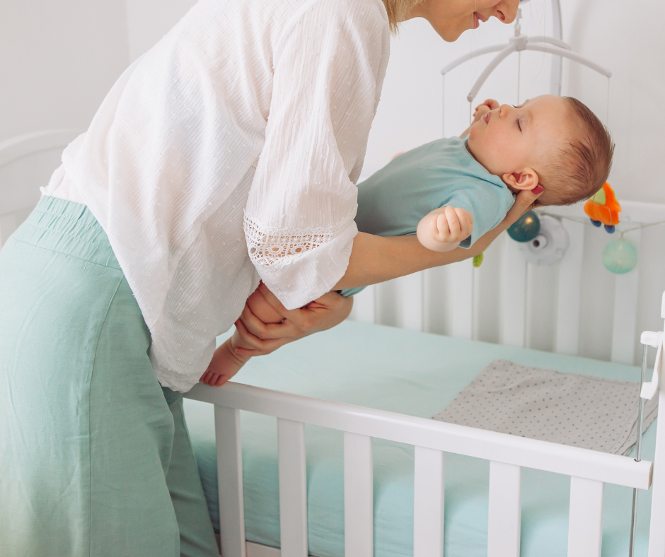 Parent putting baby in cot