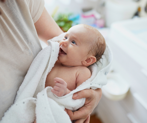 A baby wrapped in a towel after bathtime