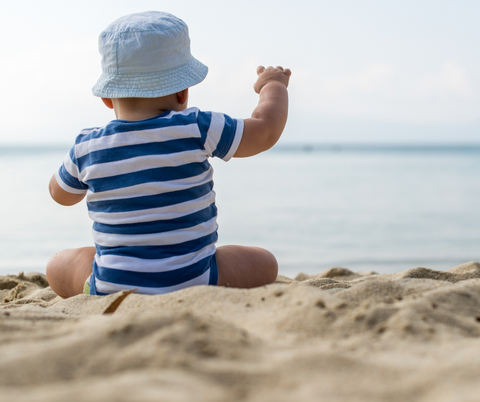 Baby on the beach covered up